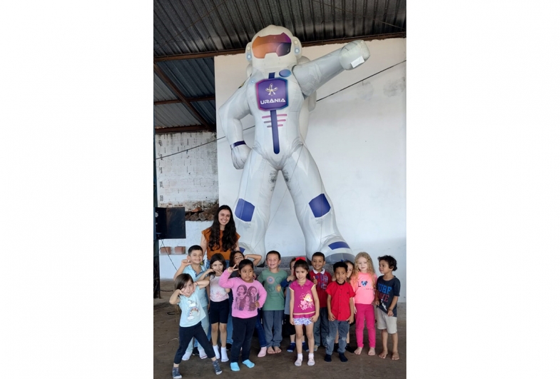 O boneco Urânia recebe a turma com alegria e convida todos para embarcar na viagem