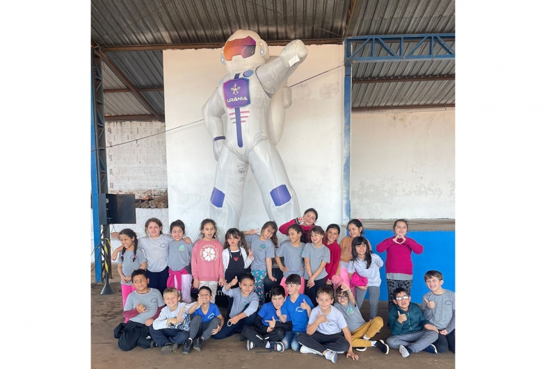 Grupo de estudantes em frente ao boneco Urânia, símbolo do evento