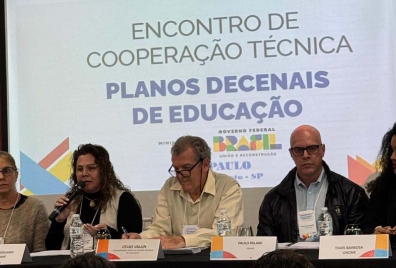 Secretária Lenita na plenária de encerramento com demais relatores e o coordenador geral do encontro