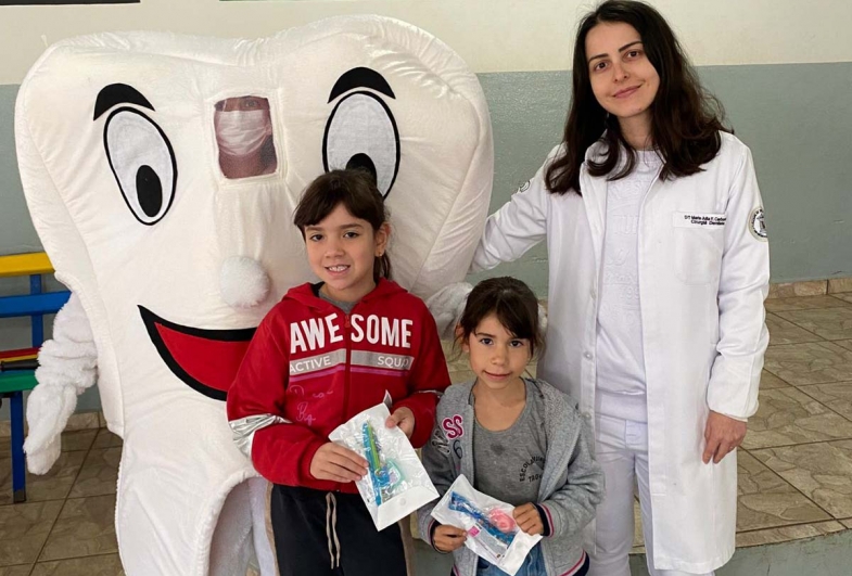 Dra. Maria Júlia com personagem “Dente Feliz” na entrega dos kits para as crianças