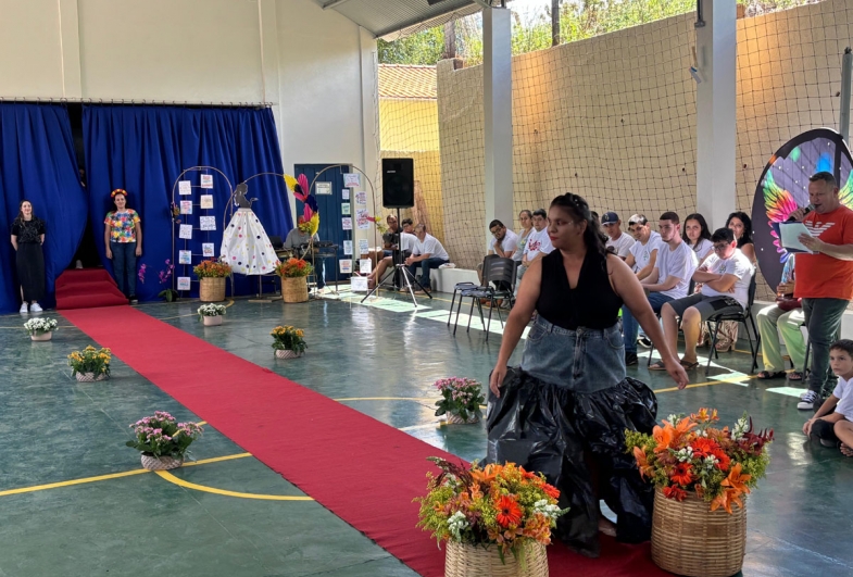 Modelos apresentam peças confeccionadas com  materiais recicláveis durante o desfile, destacando a  importância da sustentabilidade na moda