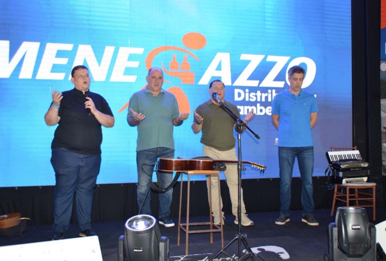 Padre Luiz Faxina fazendo as bênçãos para os funcionários ao lado dos  sócios da Menegazzo