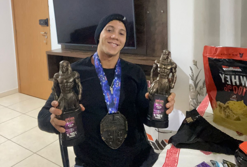 Gustavo exibe com alegria os troféus conquistados em sua primeira competição oficial