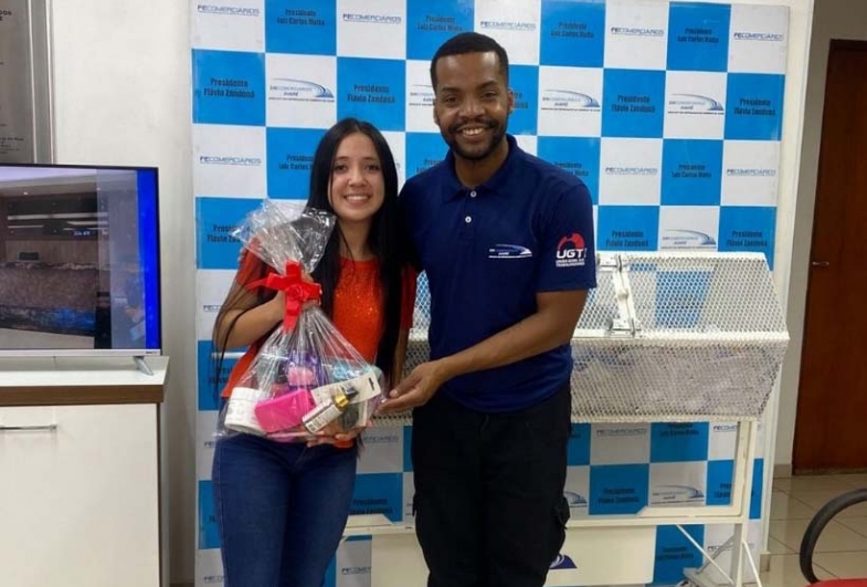Funcionário entregando o prêmio para a ganhadora