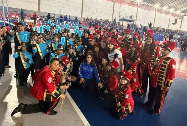 Registro da equipe da Fanfarra Municipal após a conquista do  troféu no concurso interestadual, celebrando o resultado alcançado