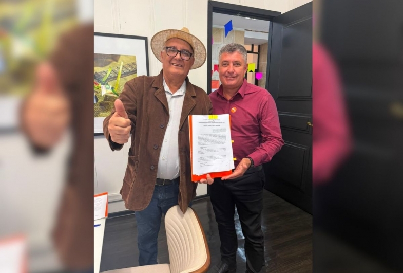 Prefeito João e Rodrigo com o  termo de convênio assinado